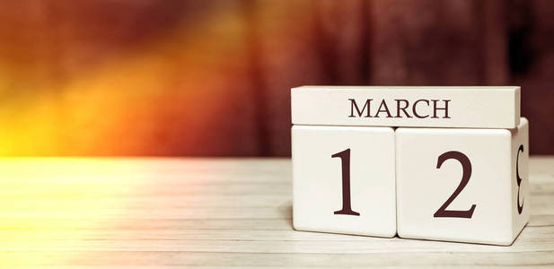 日历提醒事件概念。3月12日，阳光下，有数字和月份的木块。