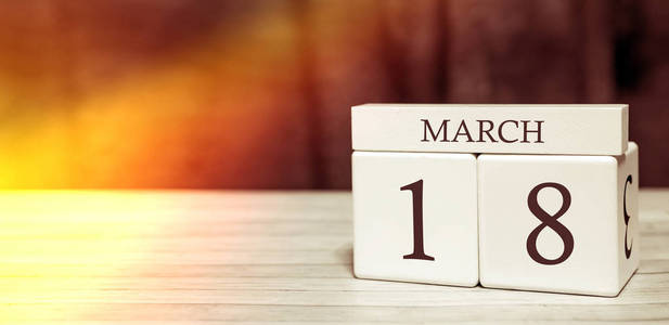 日历提醒事件概念。3月18日阳光下的数字和月份的木块。