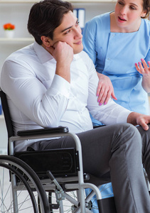 坐轮椅的残疾病人定期到医院就诊