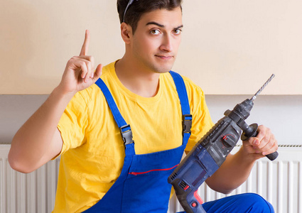 年轻的修理工承包人修理加热板