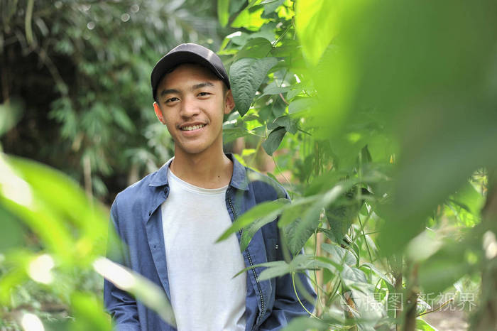 年轻的亚洲农民男性对着镜头微笑的快乐