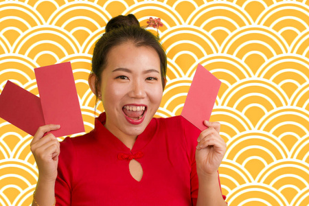 穿着传统的新年红裙子,发髻,手里拿着红包,里面装着朋友和家人的祝福