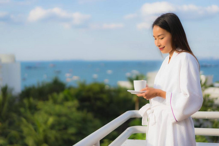 美丽的亚洲年轻女性手捧咖啡杯