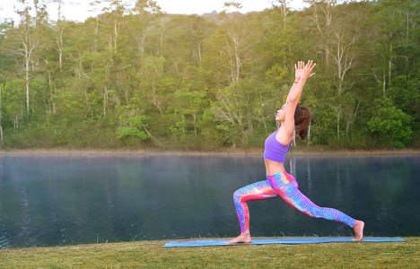 healthy woman wearing sportswear practice yoga on the lake 