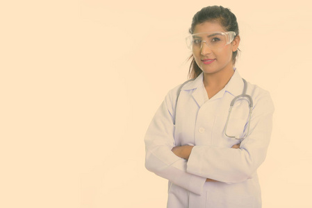 摄影棚拍摄年轻美丽的波斯女医生戴着防护眼镜，双臂交叉，与白色背景隔离