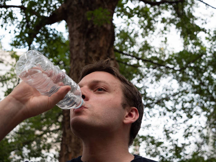 一个用塑料瓶喝水的人
