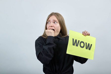 吓坏了的金发女人拿着黄色的墙纸哇