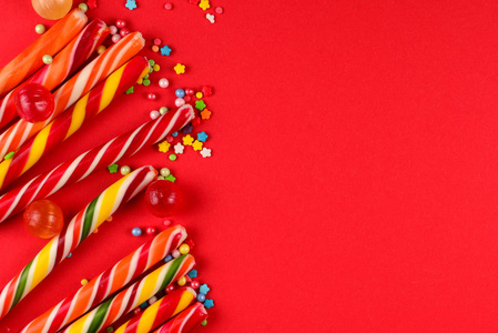 Colorful candies on a red  background. Lollipop. Top view. Copy 