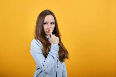 格里马斯漂亮的白人女人用手指指着鼻子,失望.照片