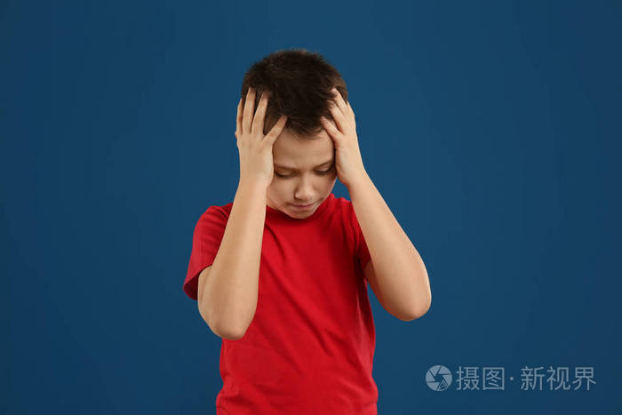 蓝色背景上情绪激动的青春期男孩肖像