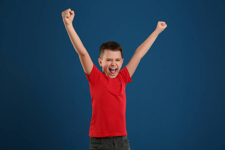 蓝色背景上情绪激动的青春期男孩肖像照片