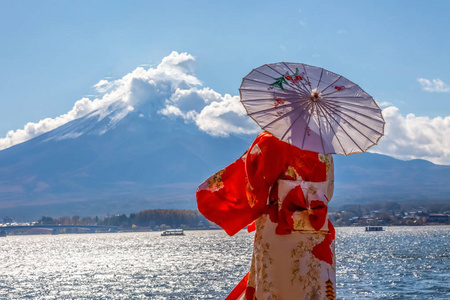 斐济火山背景下的日本女孩拿着伞。