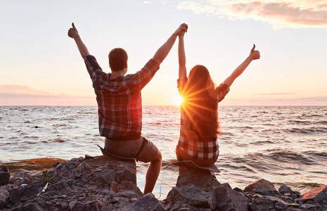 年轻浪漫情侣站在一起的剪影照片