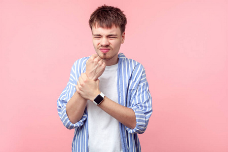 抓手腕手腕疼痛.一个心烦意乱的棕色头发男人抓着他的注射器照片