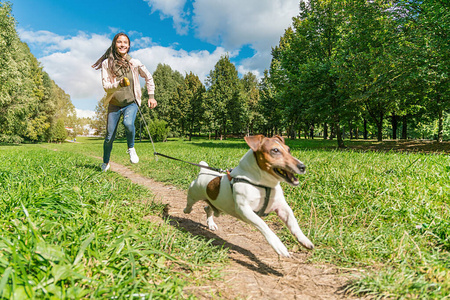 女孩在绿城公园和一只狗一起跑图片