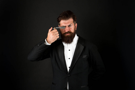 一个长着络腮胡子面色凶残的人.残忍的商人拿着剃刀.