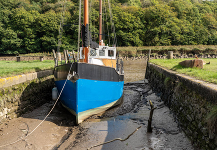 一艘渔船在德文郡的tamar潮汐河的淤泥中搁浅照片