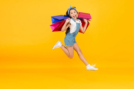 鼓舞人心的购物.交易成功.快点.快买吧.快乐的女孩拿着购物袋跳起来.