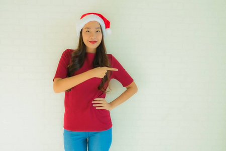 为名人戴圣诞帽的美丽的亚洲年轻女性肖像