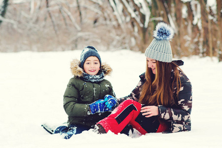 幸福的家庭。母子俩在冬季公园玩得很开心。一家人在户外玩雪。圣诞假期快乐。冬季时尚，生活方式