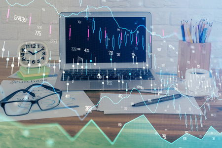 有电脑背景的图表财务信息和工作空间的双重曝光。国际网上交易的概念。