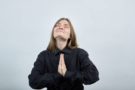 欢快迷人的金发女子双手合十，祈祷，仰望