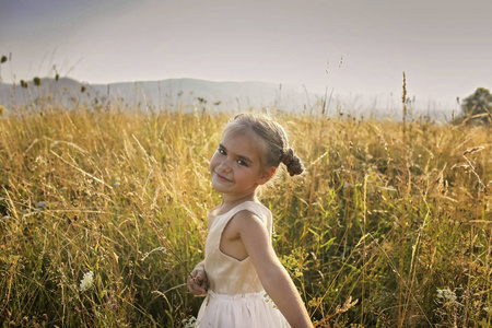 可爱的女孩在美丽的草地上翩翩起舞