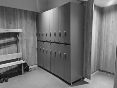 现代轻便的更衣室，用于体育设施，如学校或体育馆，所有储物柜关闭并上锁，以保护个人物品，同时进行黑白运动