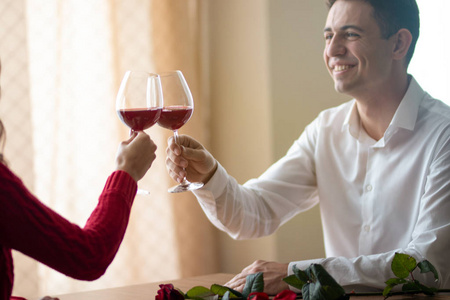 一个男人和他的女朋友在咖啡馆喝酒.桌上的红玫瑰.情人节概念.照片