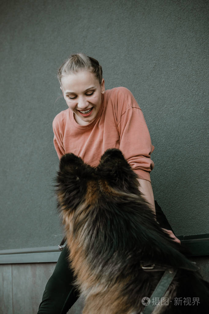 年轻漂亮快乐的女人和德国牧羊犬玩耍.真正的快乐时刻女孩玩她的狗.