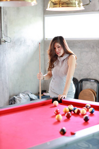 full length young beautiful asian woman playing billiards ball o