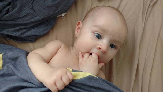 一个可爱的4个月大的婴儿躺在床上的肖像，俯视图