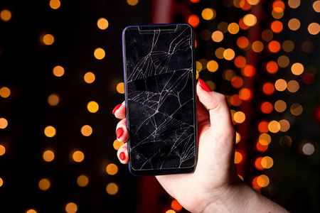 心烦意乱的女孩手中的碎玻璃屏幕智能手机,白色背景照片