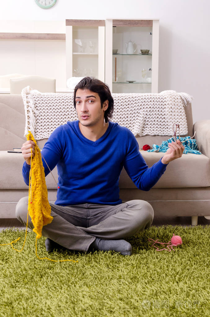 年轻帅哥在家织毛衣