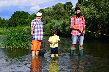 爷爷爸爸和孙子一起钓鱼。孙子和爸爸爷爷在湖边钓鱼。父亲，儿子和祖父钓鱼。