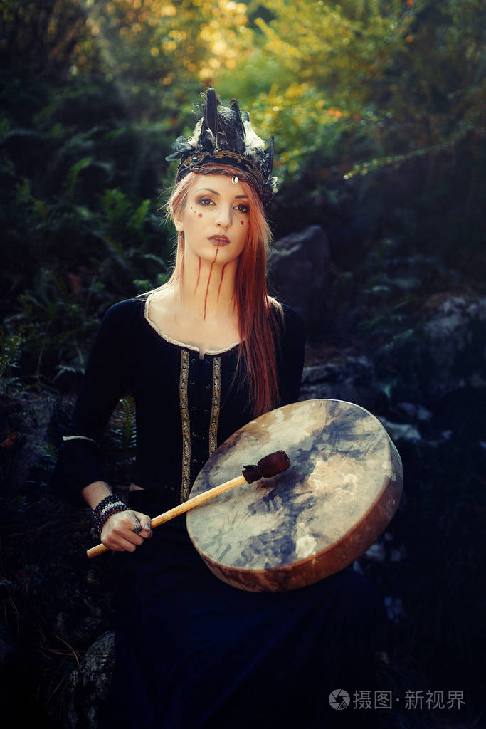 美丽的萨满教女孩在大自然中的萨满框架鼓