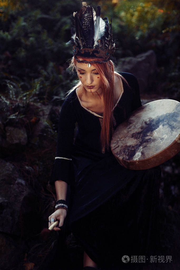 美丽的萨满教女孩在大自然中的萨满框架鼓