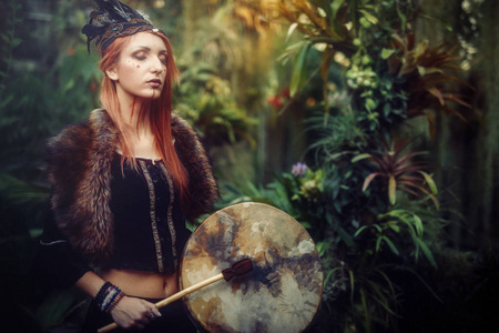 萨满鼓美丽的萨满教女孩在大自然中的萨满框架鼓.照片