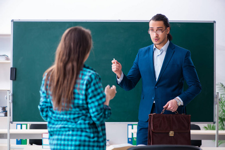 年轻帅气的老师和教室里的女学生