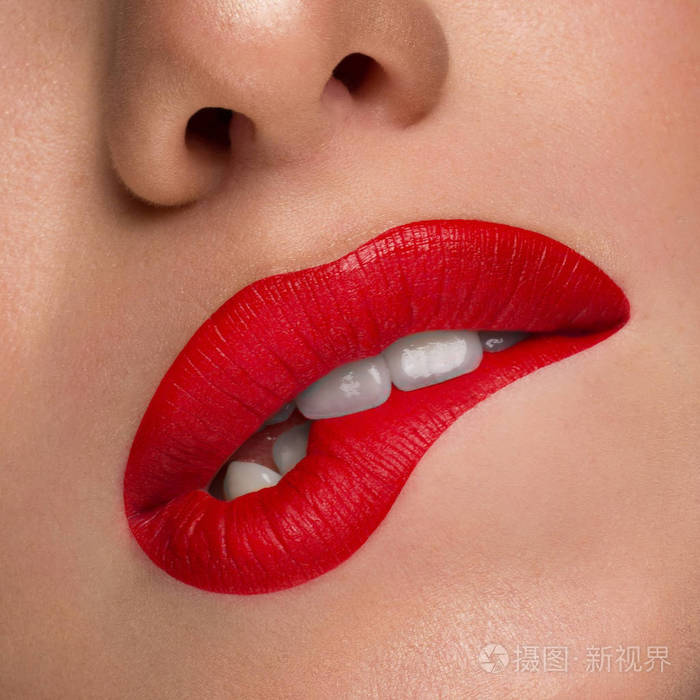 模特大性感的嘴唇,嘴张开,洁白的牙齿咬着她的下唇,诱人的嘴唇红润