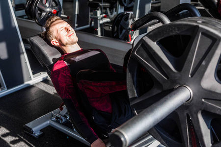 Attractive Young Man Doing Leg Press On Machine In Gym in a day 