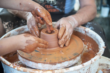 The potter makes pottery dishes on potters wheel. 