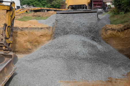挖掘机铲斗降下砾石用于基础施工