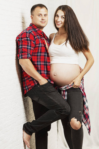 Young pregnant couple hugging and smiling. Waiting for birth and