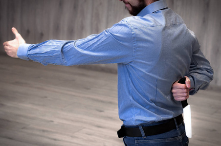 商人伸出手来握手,背后拿着一把刀照片