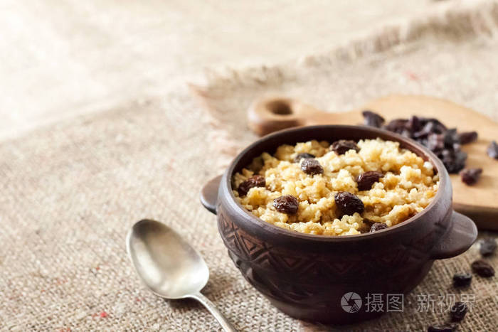 sweetmilletporridgewithdarkraisinsinceramicrusticbowl