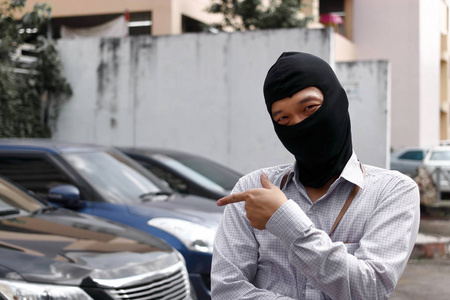 蒙面黑衣小偷试图闯入汽车照片