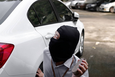 人冲洗汽车的面具拿花园水管图片