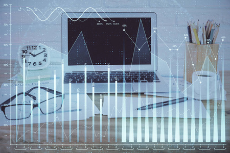 在个人电脑背景下绘制的股市图全息图。多重曝光。投资概念。