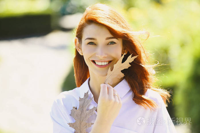快乐的微笑迷人的女孩与橙色落叶橡树.迷人的梦幻女孩享受阳光.